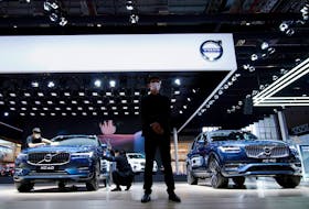 A staff member stands in front of Volvo XC60 and XC90 SUVs displayed at its booth during a media day for the Auto Shanghai show in Shanghai, China April 20, 2021.