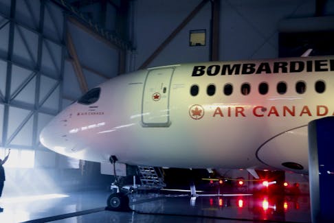 A man takes a photo of a Bombardier CSeries100 aircraft prior to a news conference in Montreal, February 17, 2016.  