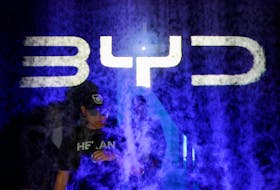 A man walks past the sign of BYD, the electric vehicle maker from China, during its launch ceremony in Jakarta, Indonesia, January 18, 2024.