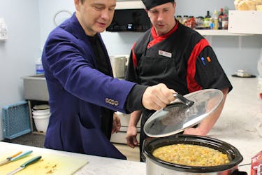Federal Conservative Leader Pierre Poilievre watches as Souls Harbour Rescue Mission cook Scott Anderson makes some turkey soup for people attending Poilievre's tour stop in Sydney Mines on Thursday. IAN NATHANSON/CAPE BRETON POST