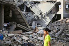 A Palestinian girl walks past the site of an Israeli strike on a house, amid the ongoing conflict between Israel and the Palestinian Islamist group Hamas, in Rafah, in the southern Gaza Strip, April 25, 2024.