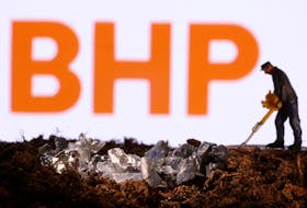 A small toy figure and mineral imitation are seen in front of the BHP logo in this illustration taken November 19, 2021.