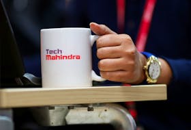 An employee holds a cup as she works at her desk inside the Tech Mahindra office building in Noida on the outskirts of New Delhi, India March 7, 2019. Picture taken March 7, 2019.