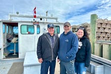 Allan Coady, left, joins his son and daughter, Bryce Alyssa, stand aboard their family's boat on April 24 at Covehead wharf. They spent the day maintaining the boat, preparing it for the upcoming spring lobster season in P.E.I. Thinh Nguyen • The Guardian
