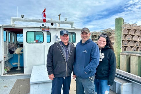 Allan Coady, left, joins his son and daughter, Bryce Alyssa, stand aboard their family's boat on April 24 at Covehead wharf. They spent the day maintaining the boat, preparing it for the upcoming spring lobster season in P.E.I. Thinh Nguyen • The Guardian