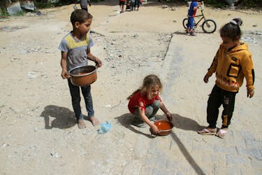 Children hold pots with food, amid the ongoing conflict between Israel and the Palestinian Islamist group Hamas, in Jabalia, in the northern Gaza Strip April 22, 2024.