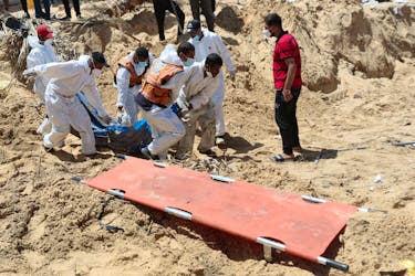People work to move into a cemetery bodies of Palestinians killed during Israel's military offensive and buried at Nasser hospital, amid the ongoing conflict between Israel and the Palestinian Islamist group Hamas, in Khan Younis in the southern Gaza Strip, April 21, 2024.