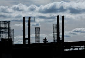 A construction worker is silhouetted against the morning sky while working on a  project in San Diego, California U.S., March 5, 2024. 