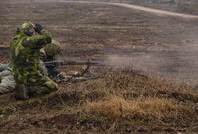 Swedish soldiers fire a machine gun on a range as they train outside Visby on the Baltic island of Gotland, Sweden, March 21, 2024.