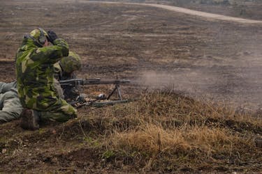 Swedish soldiers fire a machine gun on a range as they train outside Visby on the Baltic island of Gotland, Sweden, March 21, 2024.