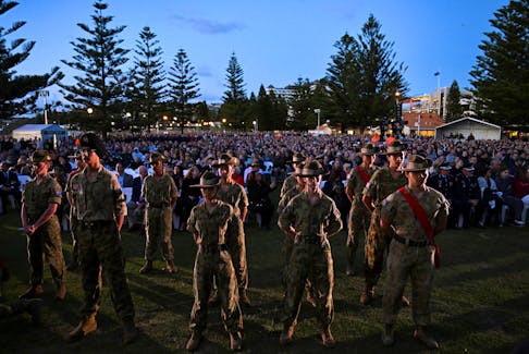 Service people stand in front of a crowd at the Coogee Anzac Day Dawn Service at Coogee Beach in Sydney, Australia, April 25, 2024.
