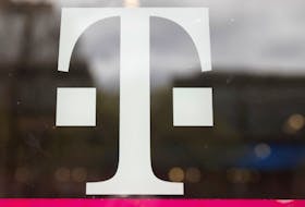 A T-Mobile logo is seen on the storefront door of a store in Manhattan, New York, U.S., April 30, 2018.