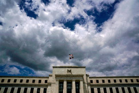 Flags fly over the Federal Reserve building on a windy day in Washington, U.S., May 26, 2017.