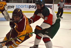 Ryan MacKinnon of the Sydney Mitsubishi Rush, left, protects the puck as he's pressured by Ayden MacKay of the Kensington Wild during Telus Cup national under-18 hockey championship action at the Membertou Sport and Wellness Centre on Friday. Kensington won the game 12-2. JEREMY FRASER/SALTWIRE