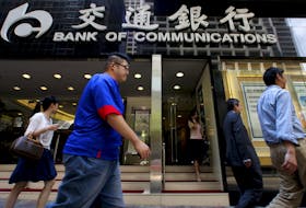 People walk past the Bank of Communications at its central branch in the financial district of Hong Kong August 19, 2009.