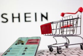 A keyboard and a shopping cart are seen in front of a displayed Shein logo in this illustration picture taken October 13, 2020.