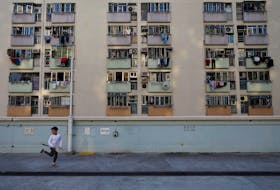 A boy runs past the residential apartments in Hong Kong, China, January 10, 2020.