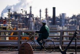 A worker cycles near a factory at the Keihin industrial zone in Kawasaki, Japan February 28, 2017.