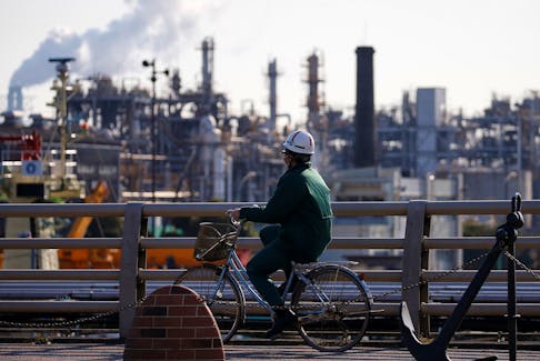 A worker cycles near a factory at the Keihin industrial zone in Kawasaki, Japan February 28, 2017.