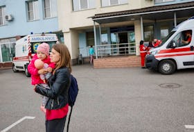 A woman with a child leaves a hospital after local authorities declared that there was possible danger of a Russian military strike, amid Russia's attack on Ukraine, in Kyiv, Ukraine, April 26, 2024.