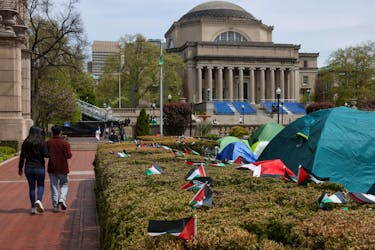 Students walk past a protest encampment on the main campus of Columbia University, organized by a group of students in support of Palestinians, during the ongoing conflict between Israel and the Palestinian Islamist group Hamas, in New York City, U.S., April 27, 2024.