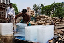 A man loads ice cubes on a cart from an ice factory, during a heatwave in Dhaka, Bangladesh, April 24, 2024.