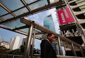A man walks past the AIA Central in Hong Kong's financial district February 25, 2011.  