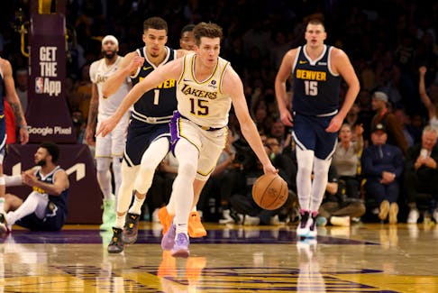 Apr 27, 2024; Los Angeles, California, USA; Los Angeles Lakers guard Austin Reaves (15) dribbles up court against Denver Nuggets forward Michael Porter Jr. (1) during the second quarter in game four of the first round for the 2024 NBA playoffs at Crypto.com Arena. Mandatory Credit: Jason Parkhurst-USA TODAY Sports