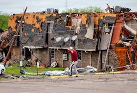 A man walks past a damaged building after it was hit by a tornado the night before in Sulphur, Oklahoma, U.S. April 28, 2024.   Bryan Terry/The Oklahoman/USA Today Network via REUTERS