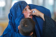 A woman receives polio drops while waiting to cross main Afghanistan-Pakistan land border crossing, in Torkham, Pakistan September 15, 2023.