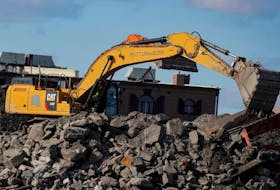 A Caterpillar (Cat) Excavator is seen working at a construction site near the New York Harbor in Brooklyn, New York, U.S., March 4, 2021. 
