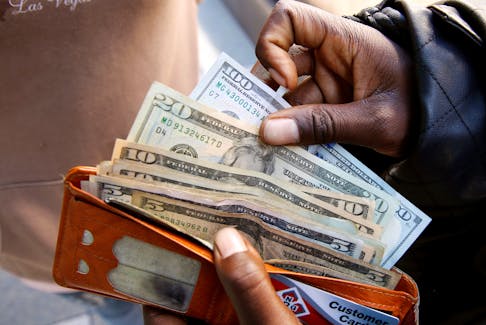 A man displays US dollar notes after withdrawing cash from a bank in Harare, Zimbabwe,  July 9, 2019.