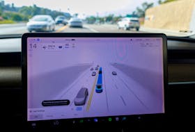 A Tesla Model 3 vehicle warns the driver to keep their hands on the wheel and be prepared to take over at anytime while driving using FSD (Full Self-Driving) in Encinitas, California, U.S., October 18, 2023.    