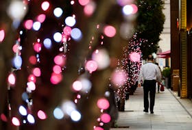 An office worker walks past illuminated trees at a business district in Tokyo, Japan January 23, 2024.
