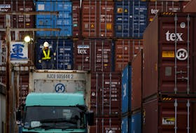 A laborer works in a container area at a port in Tokyo, Japan, March 16, 2016.
