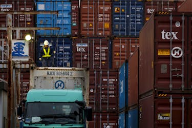 A laborer works in a container area at a port in Tokyo, Japan, March 16, 2016.
