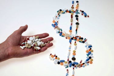 Pharmaceutical tablets and capsules are arranged in the shape of a U.S. dollar sign on a table in this picture illustration taken in Ljubljana August 20, 2014. 