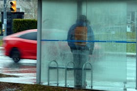 Wet wait  
   A Metrobus patron stands in a rain-covered bus shelter on Elizabeth Avenue Thursday as vehicles pass by in the miserable weather. Keith Gosse • The Telegram
