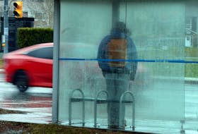 Wet wait  
   A Metrobus patron stands in a rain-covered bus shelter on Elizabeth Avenue Thursday as vehicles pass by in the miserable weather. Keith Gosse • The Telegram