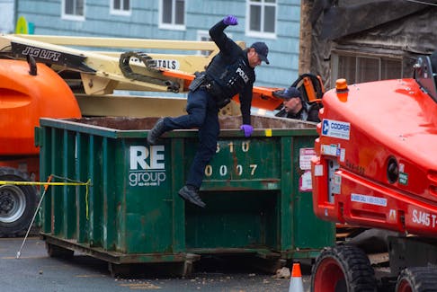 A Halifax Regional Police officer hops out of a garbage bin as police look for evidence outside an apartment building after a stabbing on Evans Avenue in Fairview on Monday, April 29, 2024.
Ryan Taplin - The Chronicle Herald