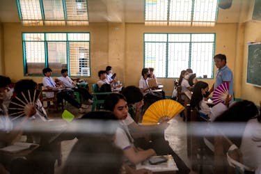 Grade 12 students use hand fans as they attend a class at the Commonwealth High School, in Quezon City, Metro Manila, Philippines, April 18, 2024.