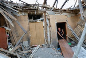 Local resident Sergei Khopta, 45, clears debris inside the destroyed house of his mother, who was taken to an intensive care unit of a hospital after she was seriously wounded by shelling, which local Russian-installed authorities called a Ukrainian military strike, in the course of Russia-Ukraine conflict in Donetsk, Russian-controlled Ukraine, April 26, 2024.