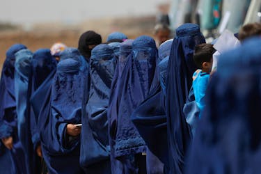 Displaced Afghan women stand waiting to receive cash aid for displaced people in Kabul, Afghanistan, July 28, 2022.