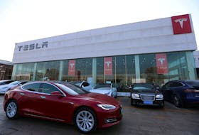 A Tesla car is driven past a store of the electric vehicle (EV) maker in Beijing, China January 4, 2024.