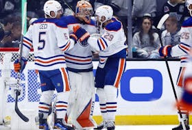 Cody Ceci (5), Stuart Skinner (74) and Leon Draisaitl (29) of the Edmonton Oilers celebrate a 1-0 win against the Los Angeles Kings in Game 4 of their first round of the 2024 Stanley Cup Playoffs at Crypto.com Arena on April 28, 2024, in Los Angeles, Calif.