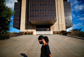A woman walks in front the Central Bank headquarters building in Brasilia, Brazil March 22, 2022.