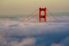 The South Tower of the Golden Gate Bridge appears above the evening fog as the suns sets on the Marin Headlands in Sausalito, California April 18, 2009.