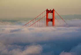 The South Tower of the Golden Gate Bridge appears above the evening fog as the suns sets on the Marin Headlands in Sausalito, California April 18, 2009.