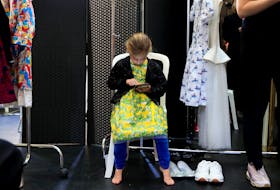 A girl looks at a mobile phone backstage before a show during Kids Fashion Week Paris in Paris, France, February 15, 2019.