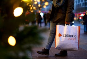 File photo: A person with a shopping bag of Zalando outlet  walks along Kurfuerstendamm shopping street looking for bargains on the second weekend of advent in Berlin, Germany, December 3, 2022.